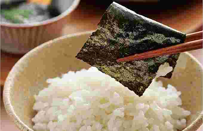 ご飯を海苔で包んでいる様子