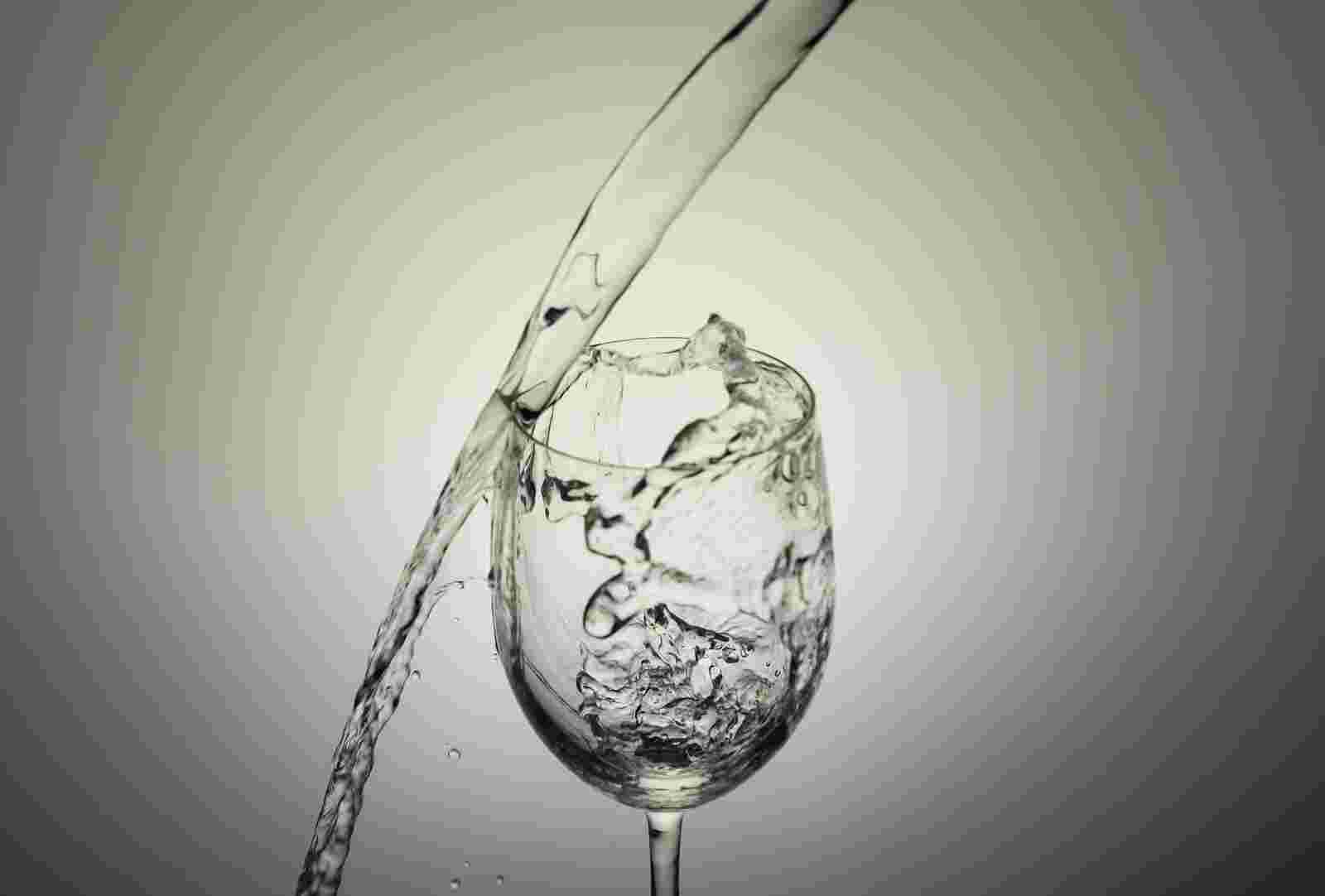 コップに水を注ぐがこぼれている様子