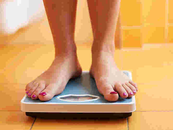 女性が体重計に乗っている様子