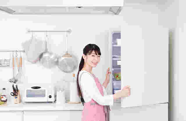 女性が冷蔵庫の扉を開けている様子