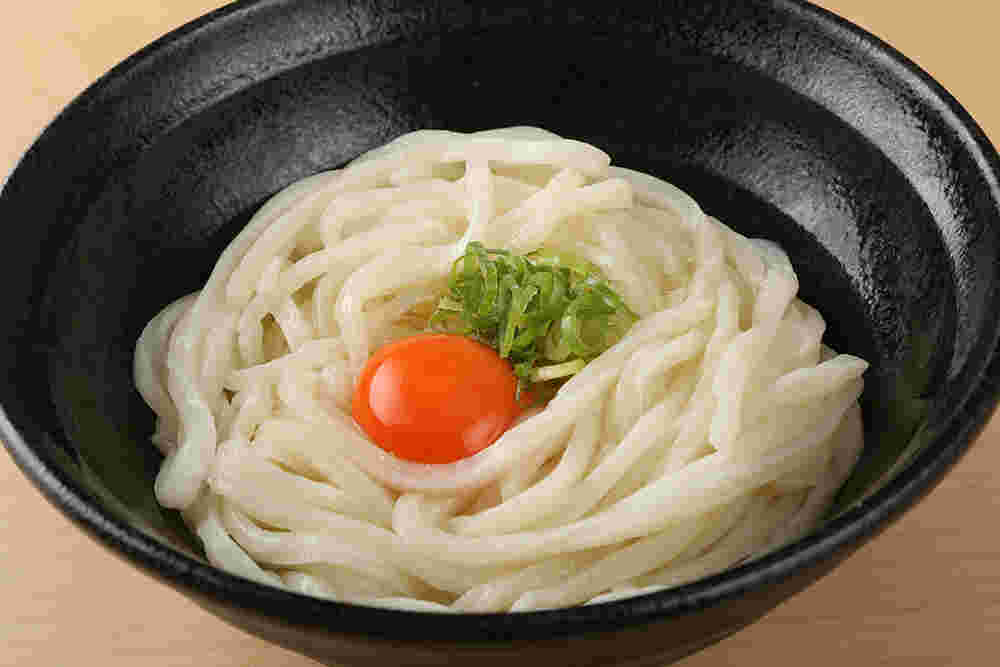 卵とねぎののったうどんの画像