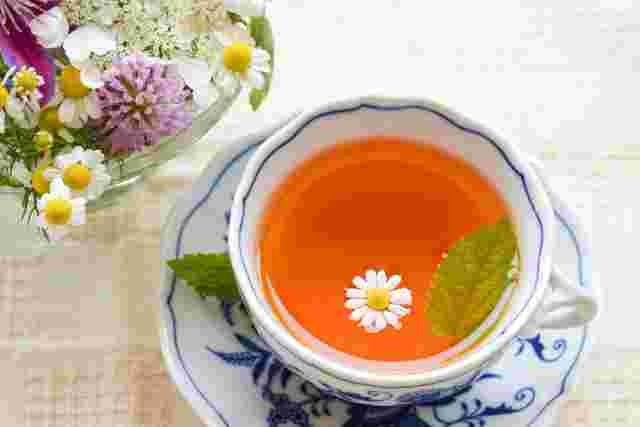 紅茶にミントと花が浮かんでいる