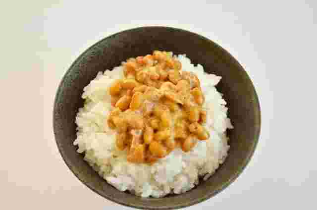 黒い茶碗に盛られた納豆ご飯