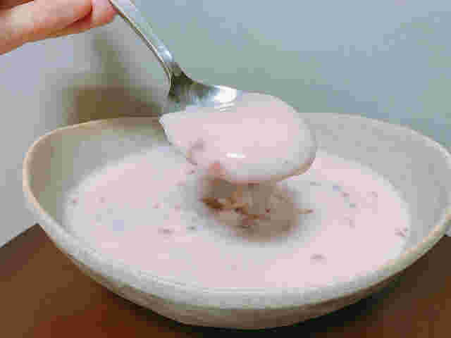 器に盛られた甘いイチゴフルーチェをスプーンですくって食べるところ