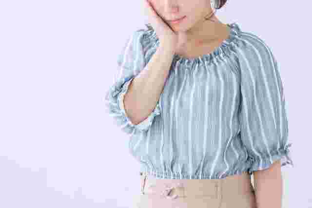失敗して片手を頬にあてて落ち込む女性