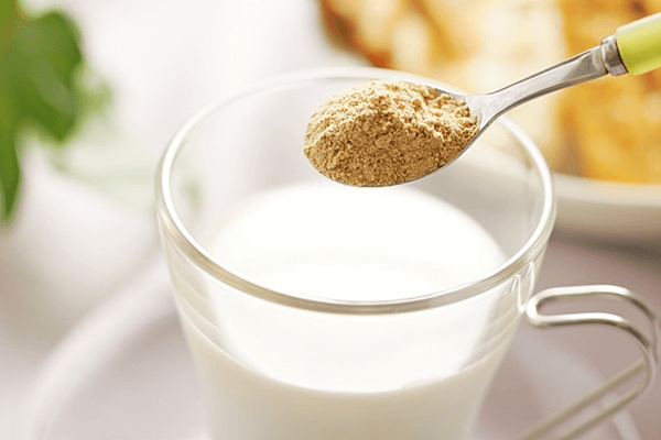 コップ1杯の牛乳にきな粉スプーン1杯を入れるところ