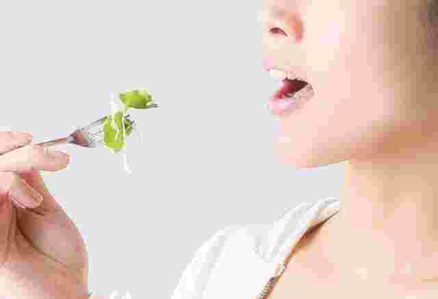 野菜を食べようとする女性の口元