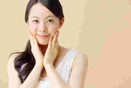 両手を頬に当て微笑んでいる女性