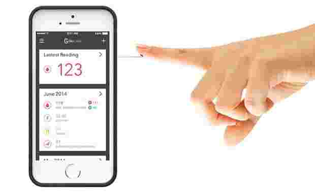 スマートフォンで血糖値を測っている手