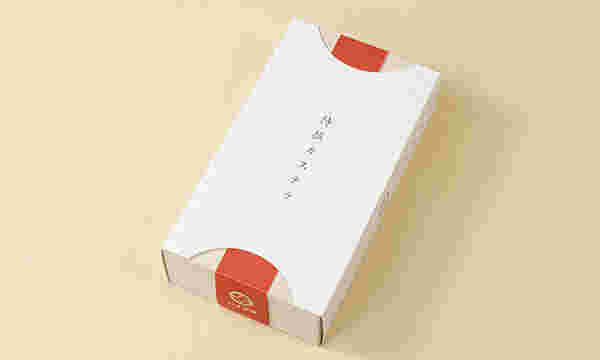 白い箱にオレンジのらいんの入ったカステラ