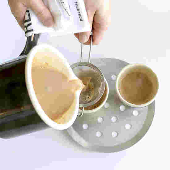 チャイを茶漉しで漉しながらカップに注いでいるところ