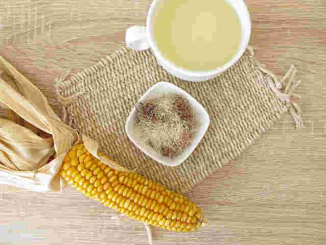 とうもろこしとカップに入ったコーン茶の画像