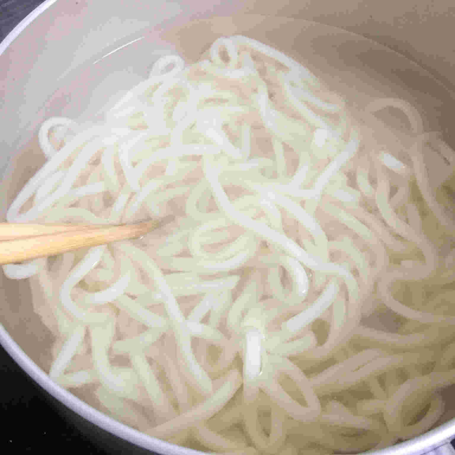 うどんを菜箸でほぐす