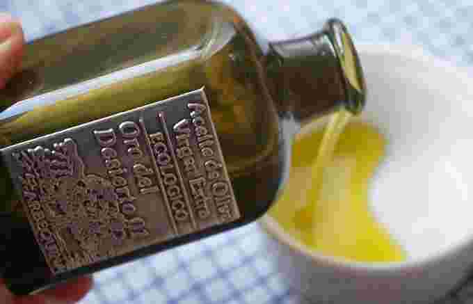 オリーブオイルのボトルから小皿に出している様子