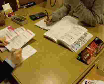 友人と教科書や参考書を広げて勉強中