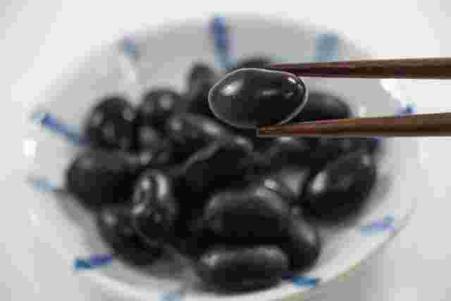 黒豆を箸でつかんでいる