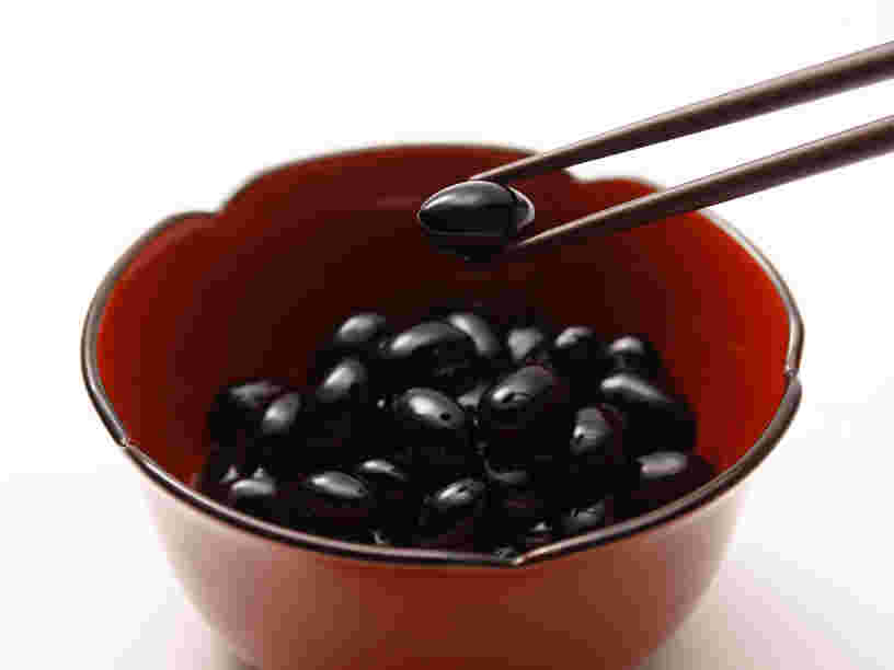 黒豆1粒をつかんでいる