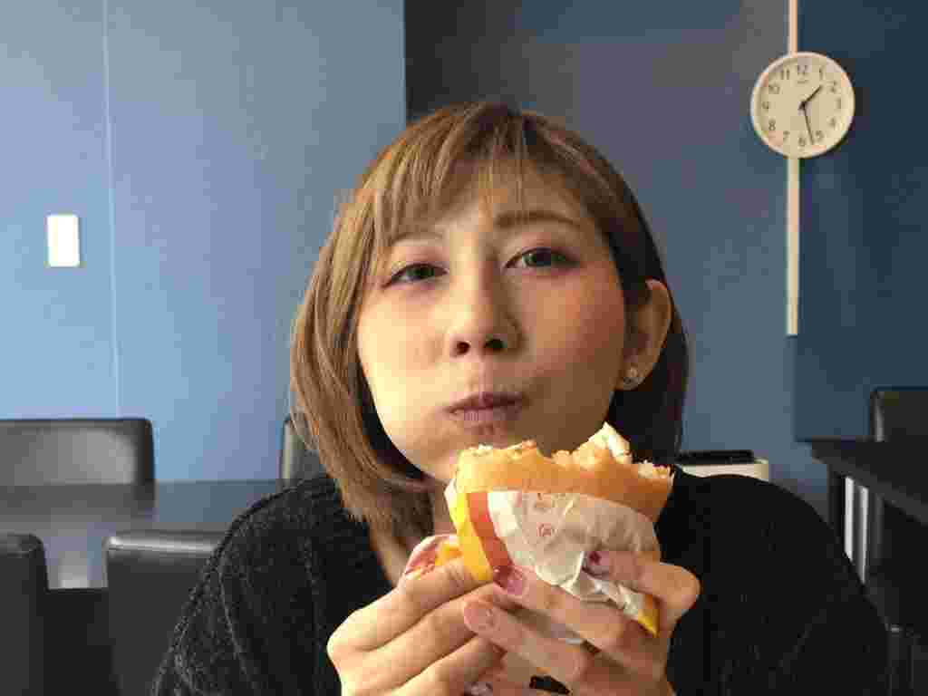 ハンバーガーをほおばる女性