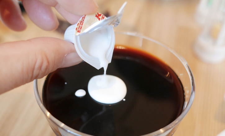 コーヒーにフレッシュを入れている写真