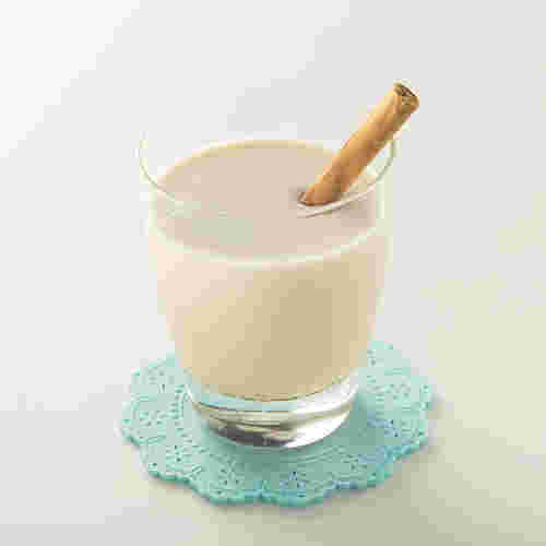 グラスに入ったきな粉牛乳にシナモンスティックがささっている様子