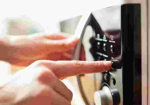 電子レンジのボタンを押す手