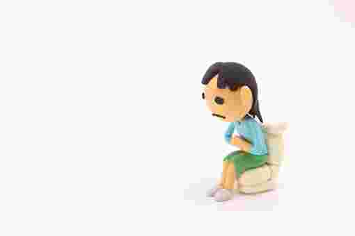 トイレに腰掛ける女性の人形