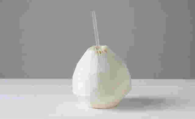 皮をむいたココナッツの実にストローがささっている
