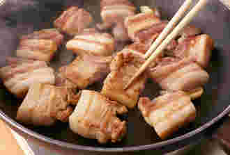 豚肉をフライパンで焼いている画像