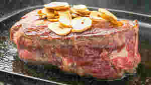 鉄板で焼かれた肉厚のステーキニンニク添え
