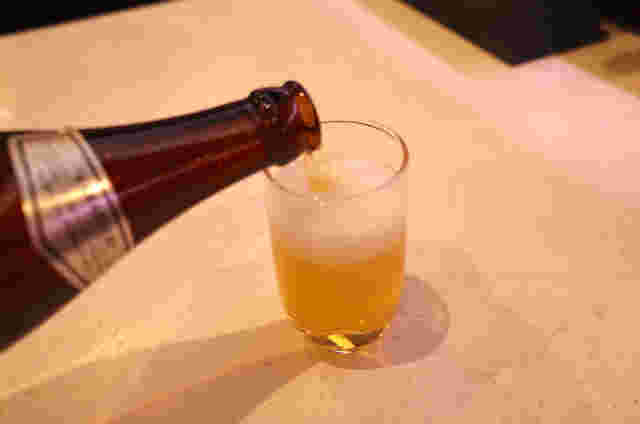 ビールをグラスにそそいでいる