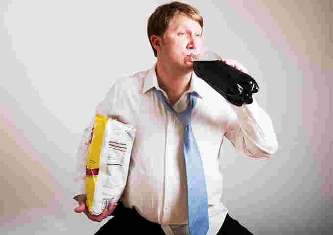 コーラとお菓子を食べすぎる男性