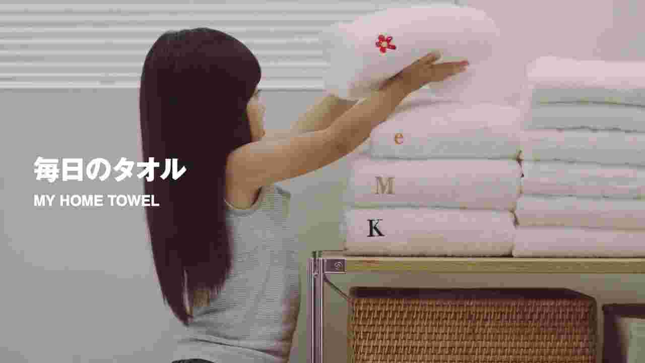 刺繍のされたタオルを積み上げる女の子