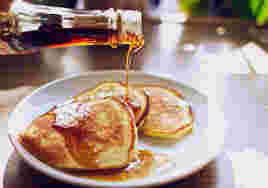 パンケーキにメープルシロップをかけるようす
