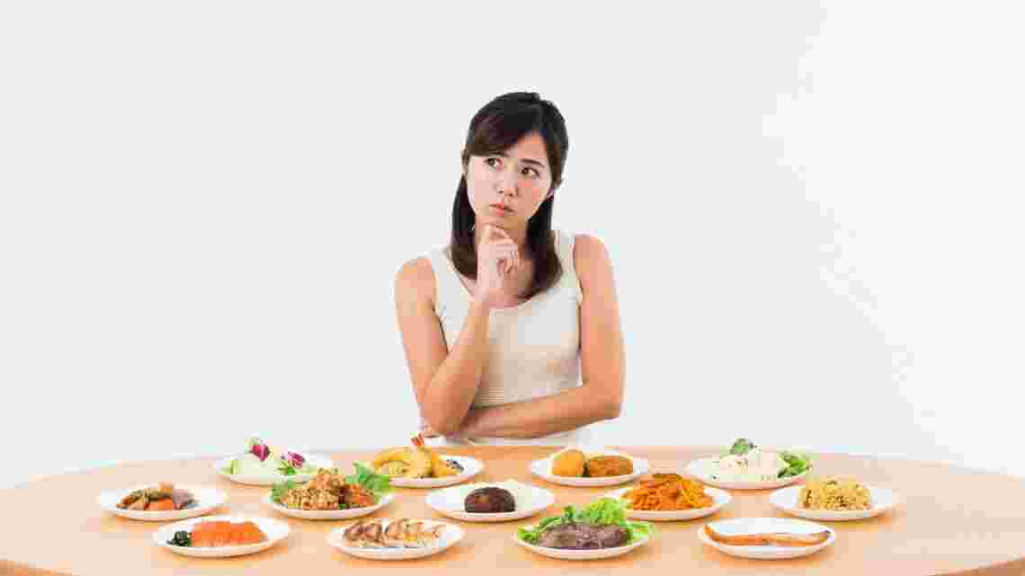 食べ物の前で悩む女性