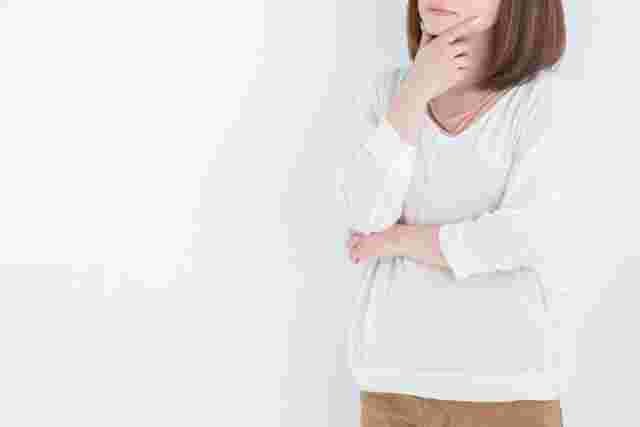 手をあごに当てて悩む女性