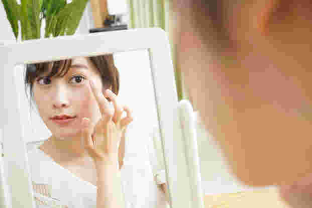 鏡を見て美白効果を確かめている女性