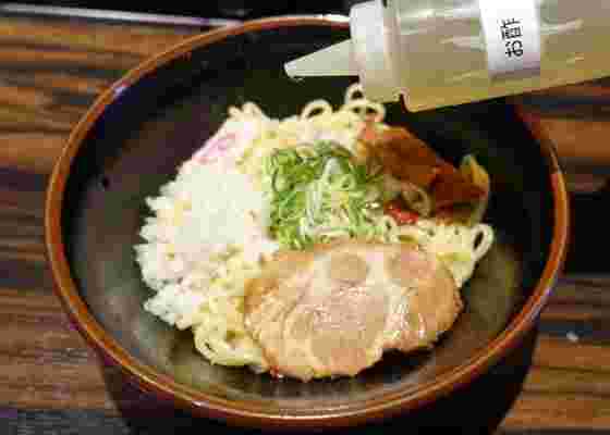 油そばに酢を加えている