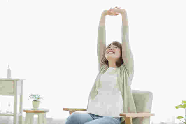 両手を伸ばして深呼吸する女性の様子