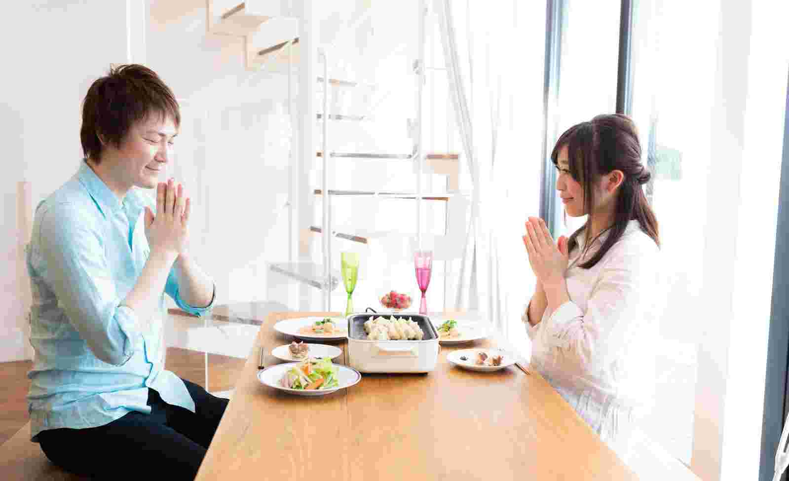 男女2人が食事の前にいただきますをしているところ