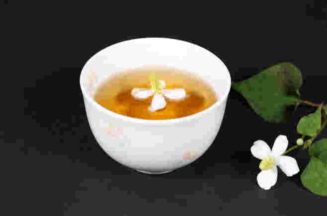 お花が浮かんだどくだみ茶の入ったカップ