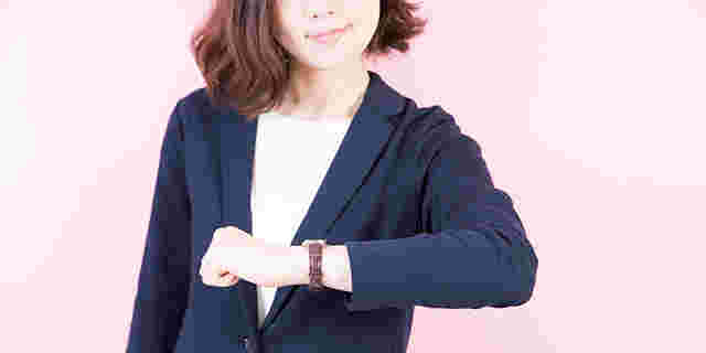 女性が腕時計を確認している写真