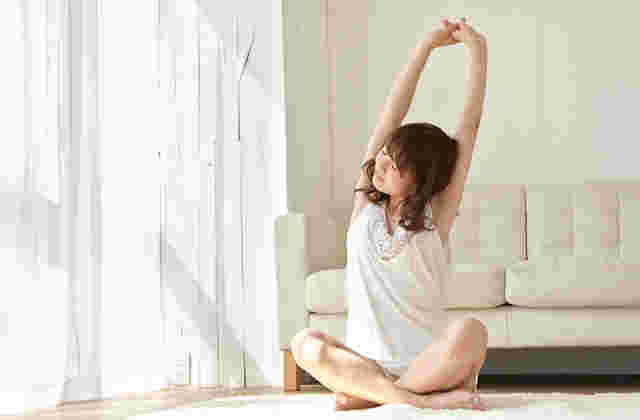 窓際でストレッチする女性