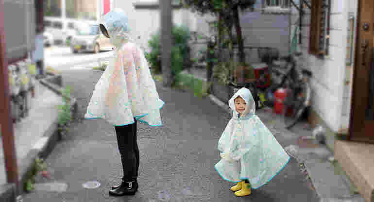 レインポンチョを着ている親子の画像