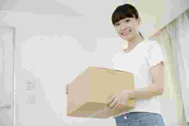 段ボールを持ち上げる女性