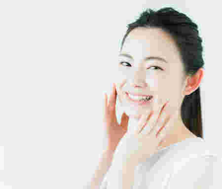 頬に手を当てて美肌効果を実感している女性