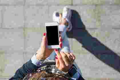 道でスマホをタッチしようとしている女性