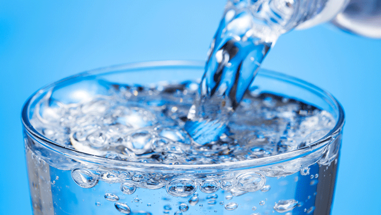 透明のコップに並々とつがれた水の様子