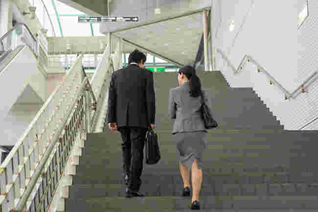 階段を上る会社員の男性と女性