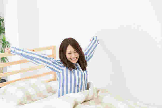 ベッドで朝起きた女性