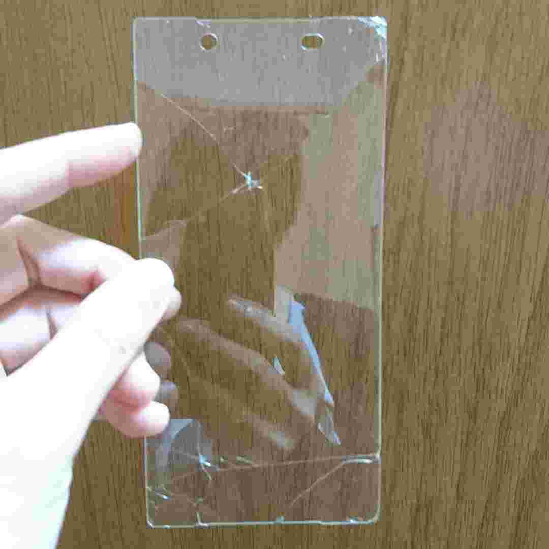 キズだらけのガラスフィルムをスマホから取り除いて手に持つ